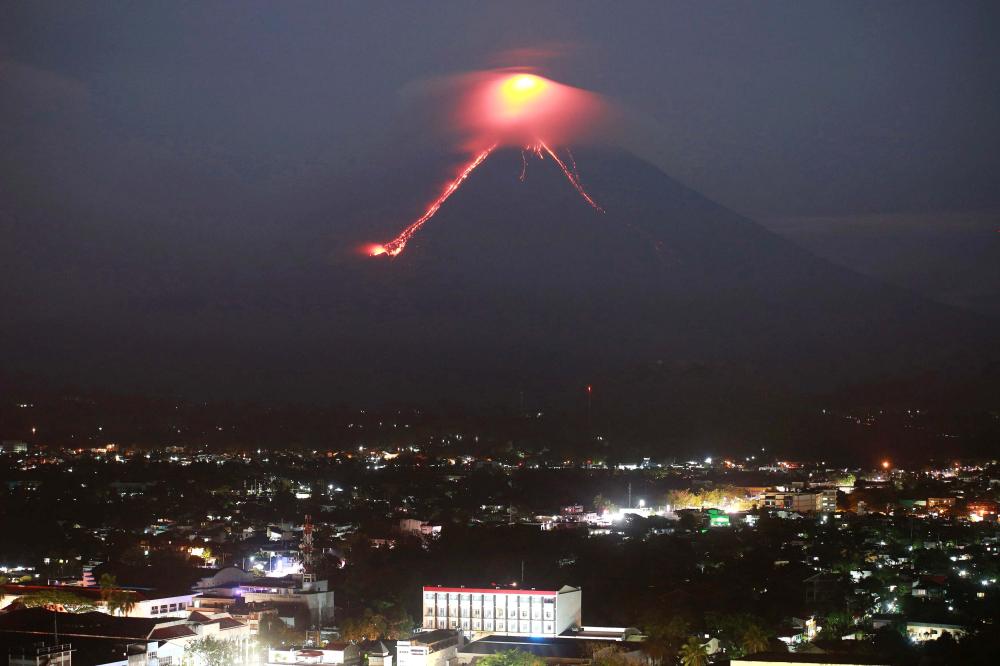 Lava from Mayon volcano is seen as it erupts in Legazpi. The Philippines raised the alert level for the country's most active volcano twice in 24 hours on Sunday, meaning that a hazardous eruption is possible within days. — AFP