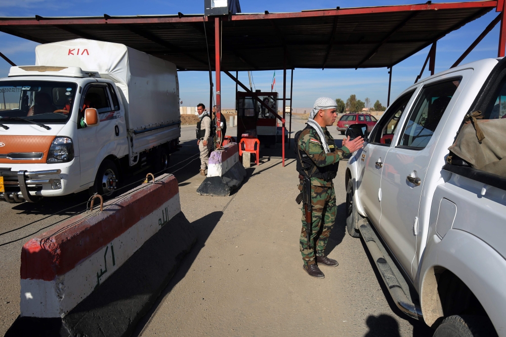 An Iraqi fighter from the paramilitary units of the Hashd Al-Shaabi mans a checkpoint in Bartala, east of Mosul. — AFP