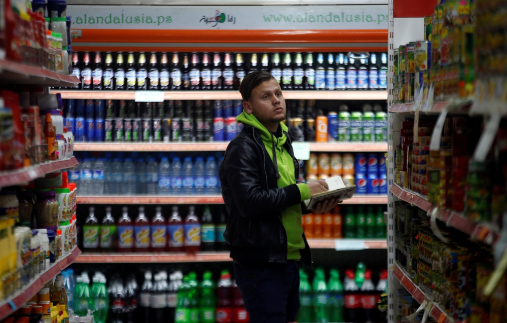 A worker counts items at a supermarket in Gaza City. — Reuters