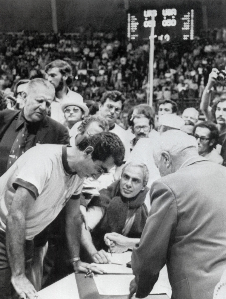 This file photo taken on Sept. 10, 1972 shows Hans Iba (center), coach of the US Basketball team looking over the shoulder of a referee as he explains to officials the circumstances of the final seconds of the game (51-50) giving Russia the gold medal, during the Munich Olympics. A controversial Olympic basketball showdown between the Soviet Union and the US has become the subject of a record-breaking Russian film, as the country's sports are mired in a doping scandal and relations with Washington are at a low point. 