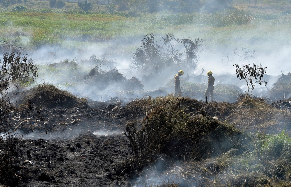 Indian firefighters try to douse a fire at Bellandur Lake in Bangalore on Saturday. Bellandur Lake which is among the highly polluted lakes in the city caught fire due to suspected effluents. — AFP