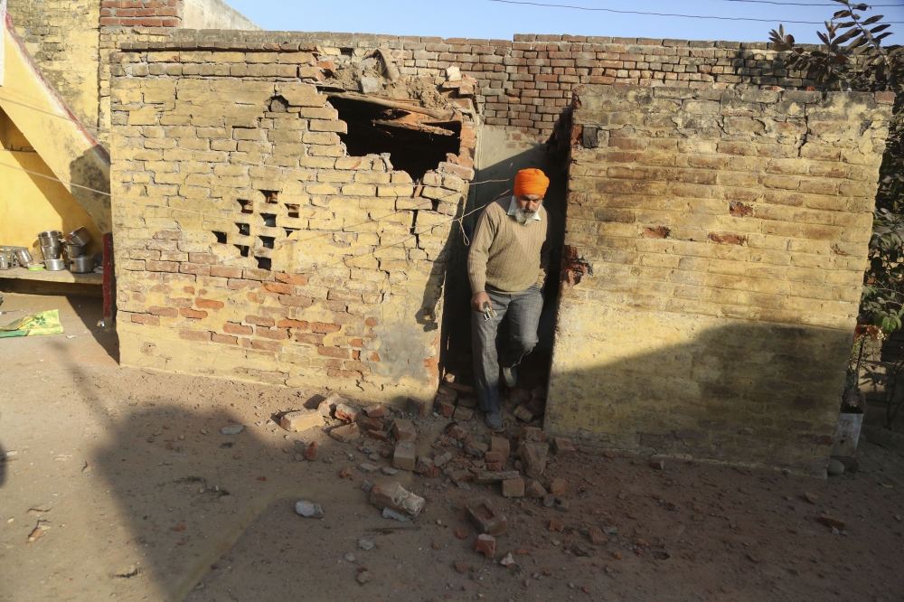 An Indian man inspects a house damaged allegedly due to firing from the Pakistan side of the border at Korotana village, in Ranbir Singh Pura district of Jammu and Kashmir, India, Friday. — AP