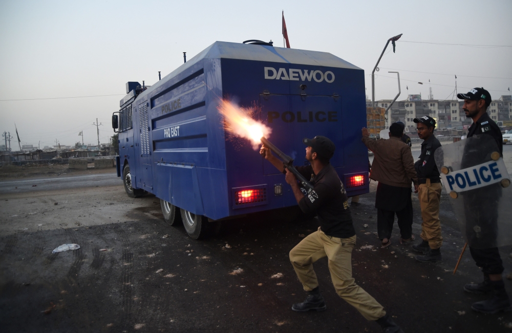 A Pakistani policeman fires teargas shell towards demonstrators during a protest against the killing of a Naqeebullah in an alleged police encounter, in Karachi on Friday. — AFP