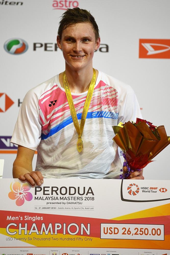 Denmark’s Viktor Axelsen poses on the podium after defeating Kenta Nishimoto of Japan in the final of the 2018 Malaysia Masters Badminton Tournament in Kuala Lumpur Sunday. — AFP