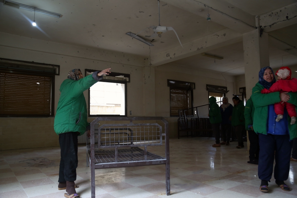 Syrians inspect damage at a psychiatric hospital after it was hit by mortar fire leaving at least one patient killed and over a dozen wounded, in the rebel-held town of Azaz in northern Syria. — AFP