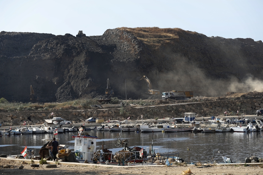 In this June 22, 2017, photo, bulldozers remove waste from a landfill to be moved to a new land reclamation site in Bourj Hammoud east of Beirut, Lebanon. — AP