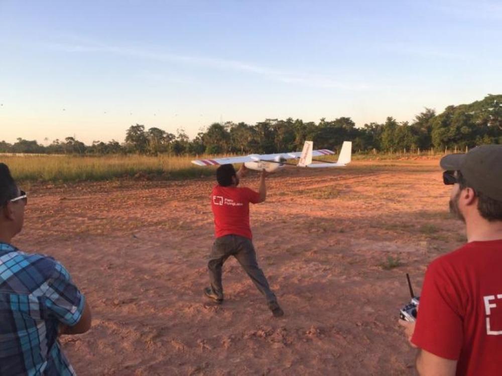 A member of WeRobotics' Peru FlyingLabs hand launches a cargo drone in Pucallpa, Peru. - Thomson Reuters Foundation