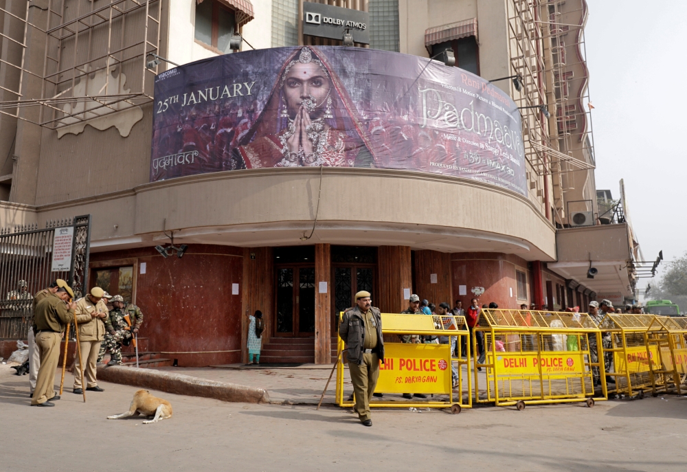 Security personnel stand guard outside a theater after the release of Bollywood movie 