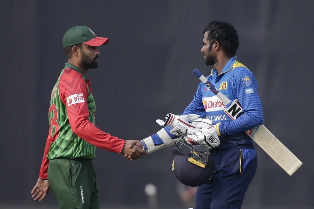 Sri Lanka's Upul Tharanga, right, shakes hand with Bangladesh's Tamim Iqbal after win against them during the Tri-Nation ODI cricket series in Dhaka, Bangladesh, Thursday. — AP