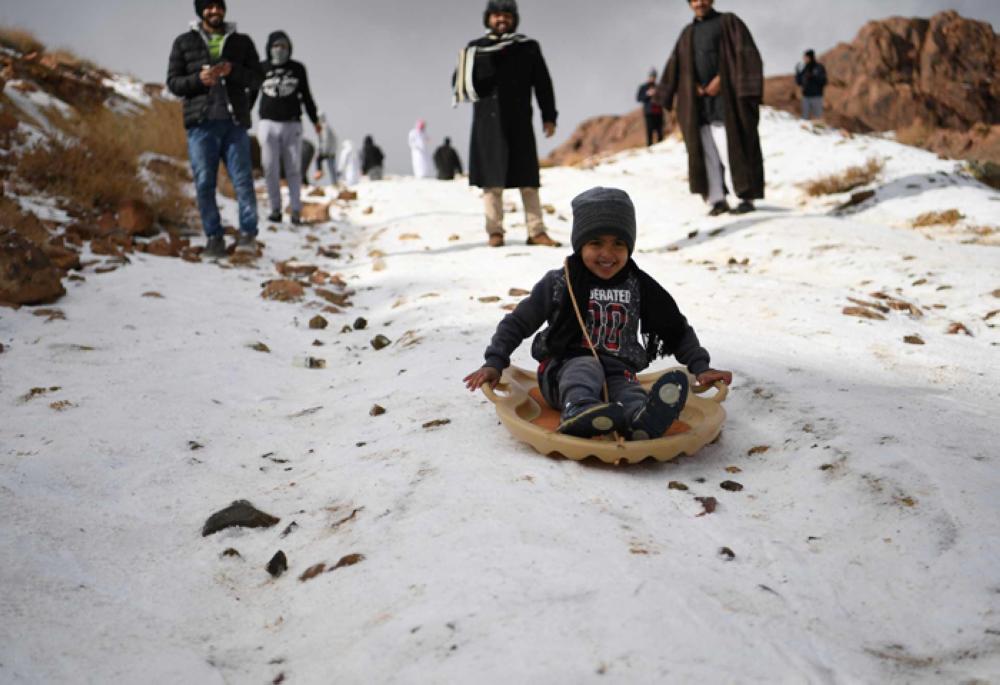 Families enjoy day of sledding as snow drapes Saudi Arabian mountains