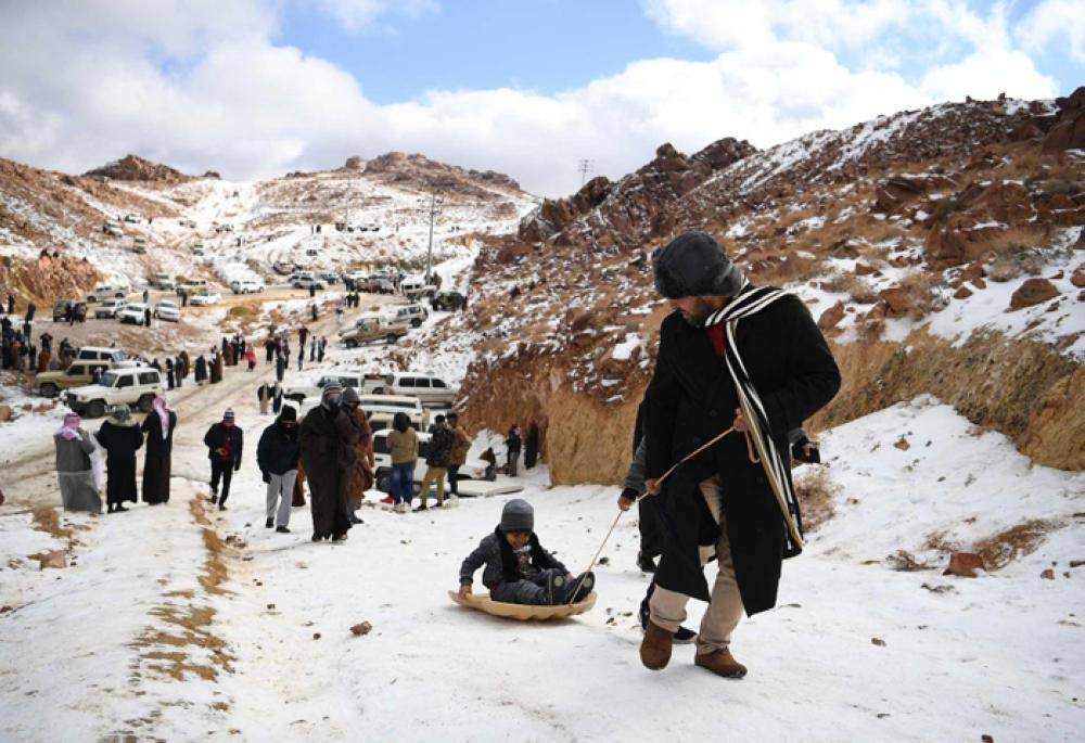 Families enjoy day of sledding as snow drapes Saudi Arabian mountains