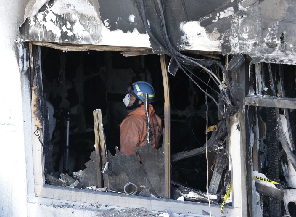 A firefighter inspects a burned hospital after a fire in Miryang, South Korea, on Saturday. — AP