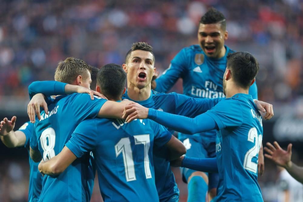 Madrid’s players celebrate after scoring against Valencia during their Spanish league match at Mestalla, Valencia, Saturday. — Reuters