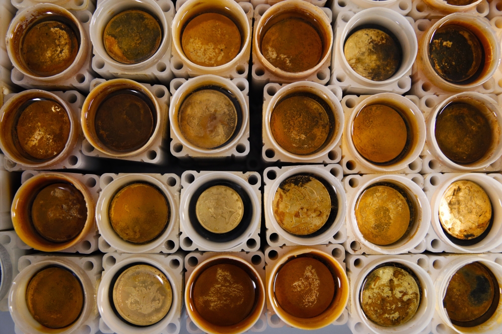 Rust-covered gold coins recovered from the SS Central America steamship that went down in a hurricane in 1857, sit in small containers filled with water while being restored in a laboratory in Santa Ana, California, in this Jan. 23, 2018 file photo. — AP