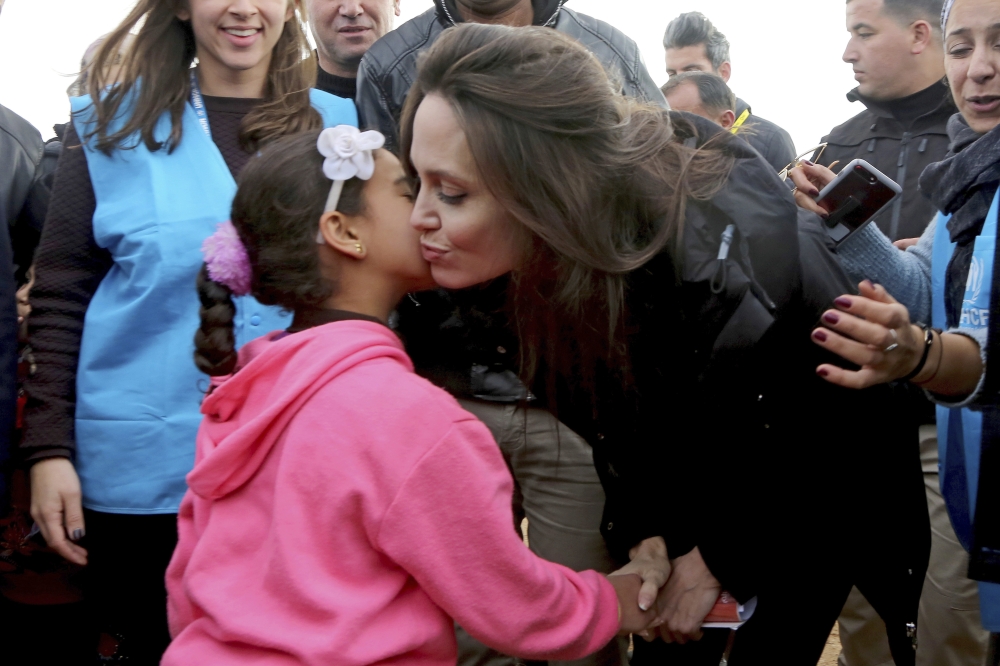 The UN refugee agency's special envoy, actress Angelina Jolie kisses a Syrian child during her visit to the Zaatari Syrian Refugee Camp, in Mafraq, Jordan on Monday. - AP