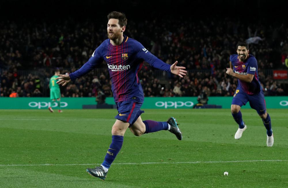 Barcelona’s Lionel Messi celebrates scoring their second goal with Luis Suarez during their Spanish football league match against Deportivo Alaves at Camp Nou, Barcelona, Sunday. — Reuters