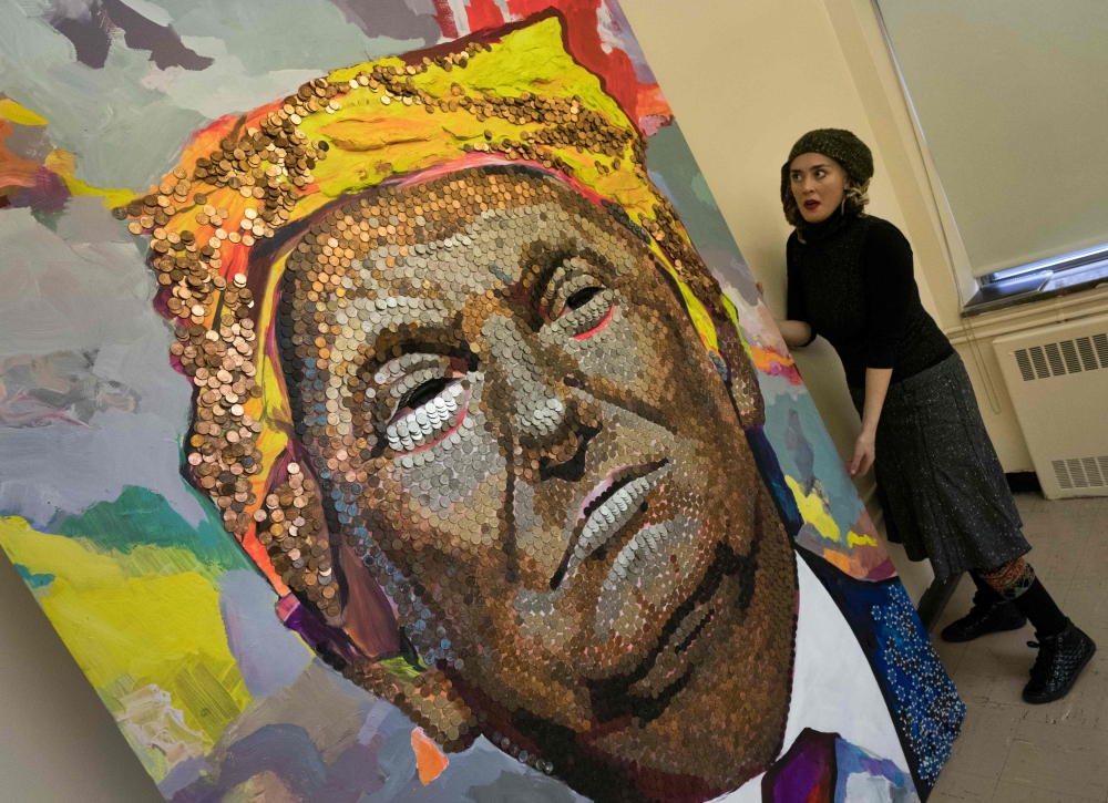Ukranian artist Daria Marchenko is seen in New York with her portrait of US President Donald Trump, made of US pennies, nickels,and dimes, in New York. — AFP