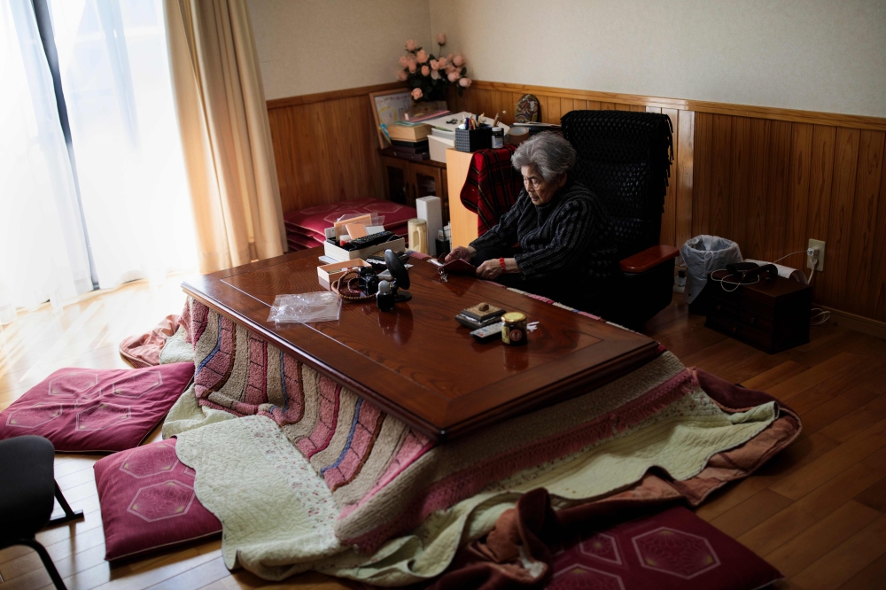 In this picture taken on Jan. 16, Kimiko Nishimoto checks her smartphone at her house in the western Japanese city of Kumamoto. The madcap Japanese great-grandmother armed with a camera and an appetite for mischief has shot to fame for taking side-splitting selfies — many of which appear to put her in harm's way. — AFP photos