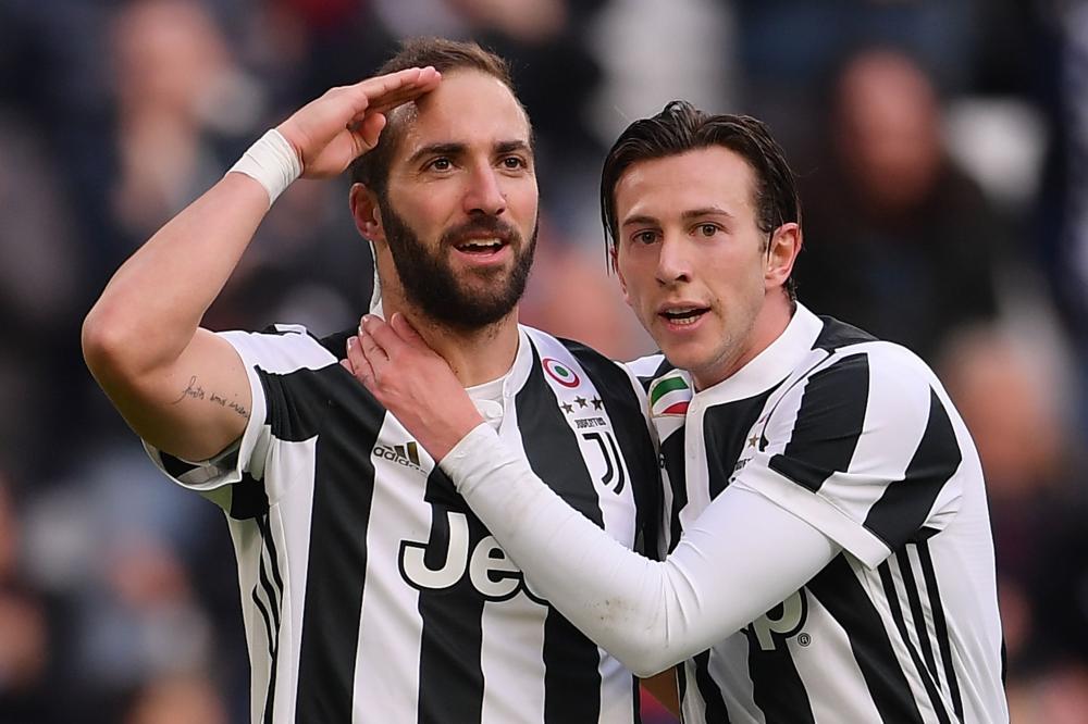 Juventus' forward Gonzalo Higuain (L) celebrates with his teammate Federico Bernardeschi after scoring a goal during the Italian Serie A football match against Sassuolo at the 'Allianz Stadium' in Turin Sunday. — AFP