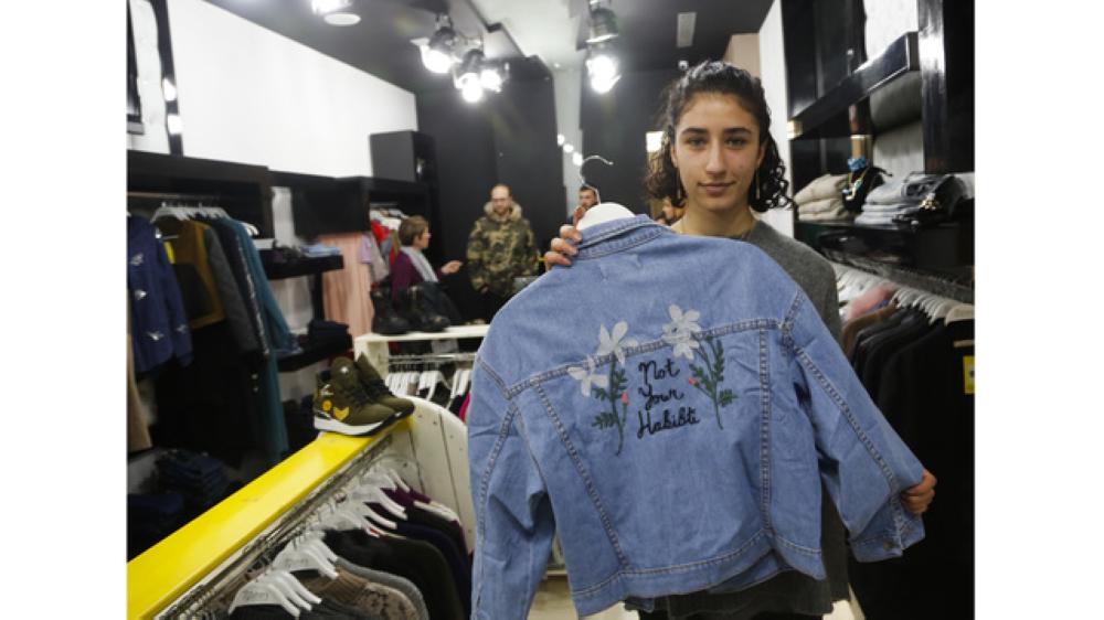 Palestinian-American Yasmeen Mjalli displays a jacket with the slogan 