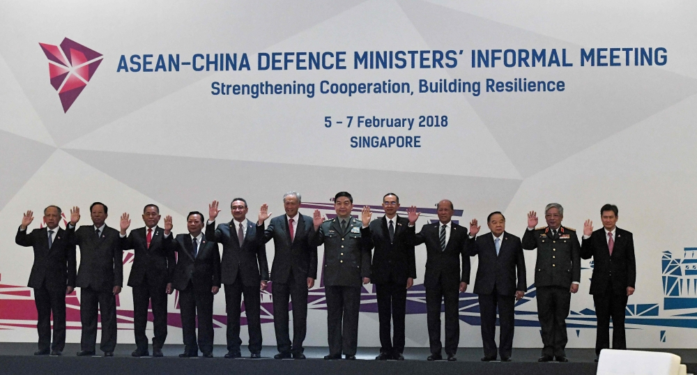 Association of Southeast Asian Nations (ASEAN) defense ministers wave during a group photo at the ASEAN Defense Ministers’ informal meeting in Singapore on Tuesday. — AFP