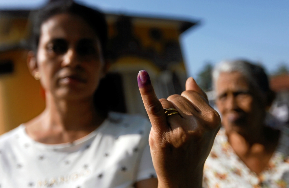 A woman shows her ink-stained finger after casting her vote at a polling station during the long-delayed local government elections in Colombo, Sri Lanka, on Saturday. — Reuters