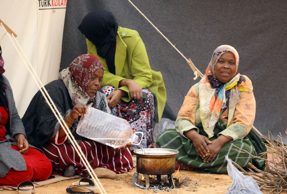 Displaced women from the Libyan town of Tawergha, 260 km east of the Libyan capital Tripoli, prepare food at a temporary camp, 20 kms from Tawergha, after they were denied entry to their hometown. — AFP