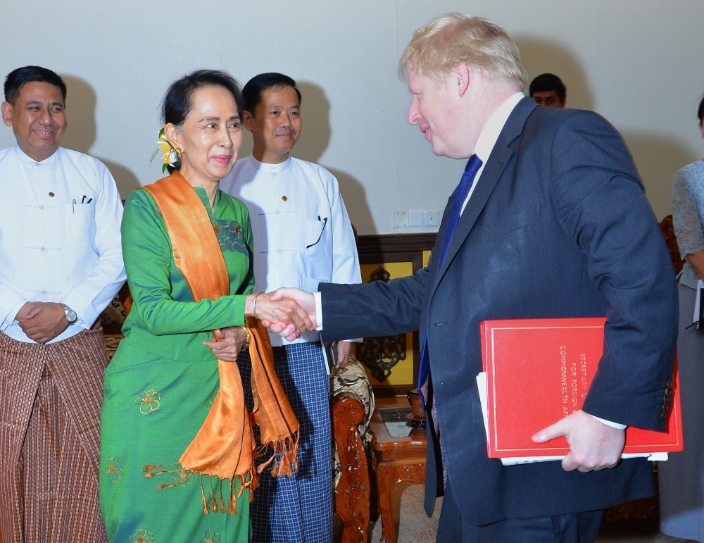 Myanmar State Counselor Aung San Suu Kyi, left, shakes hands with British Foreign Minister Boris Johnson, right, at the start of their meeting in Naypyidaw, Myanmar, on Sunday. — AFP