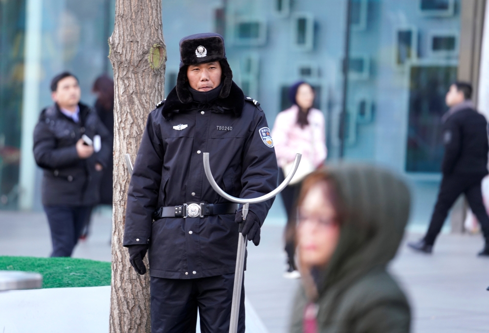 Security personnel stand guard outside the Joy City Mall in the Xidan district after a knife attack, in Beijing, China, on Sunday. — Reuters