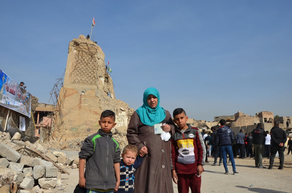 Iraqis stand in front of the destroyed Al-Hadba minaret at the Al-Nuri Mosque in Mosul's Old City during a gathering to call on international organizations to proceed with the reconstruction of the city. — AFP