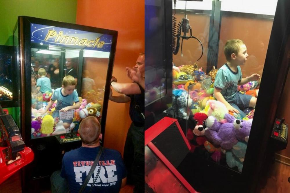 Fire fighters are seen as they attempt to rescue a boy who crawled inside a claw-style vending machine in Titusville, Florida. - AP