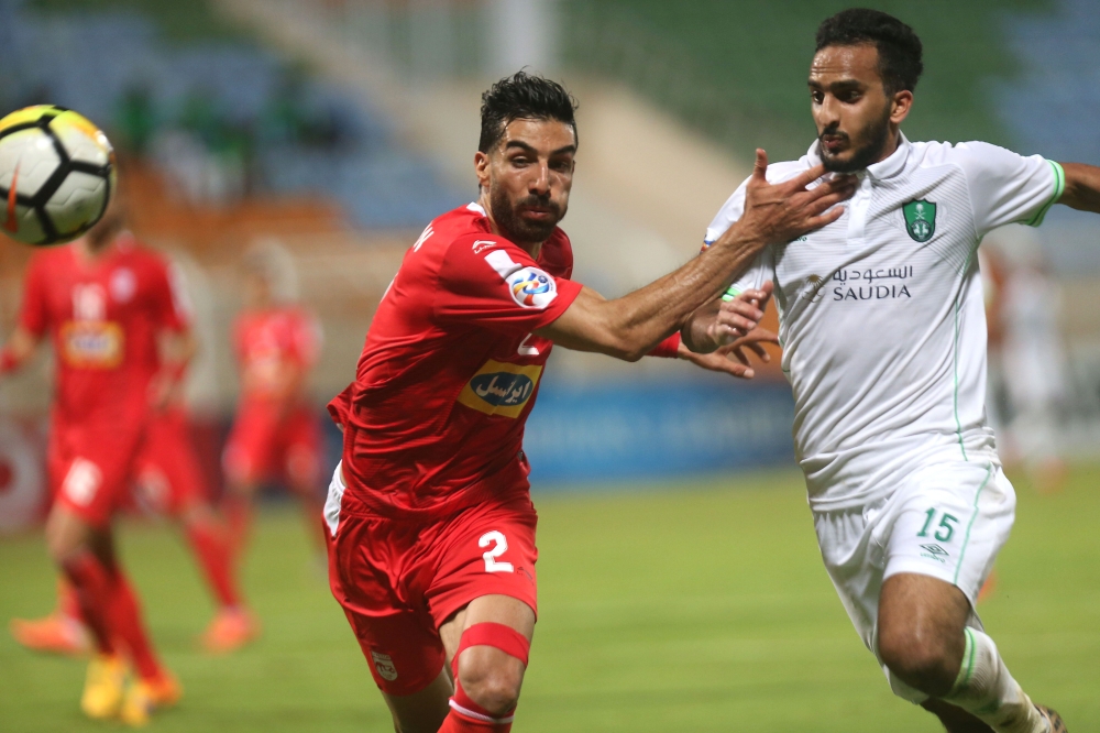 Saudi club Al-Ahli's Saleh Mohammed Al-Jaman (R) fights for the ball with Mohammad Iranpourian (L) of Iranian club Tractorsazi Tabriz during their Asian Champions League football match on Monday at the AL-Seeb stadium in Muscat. — AFP