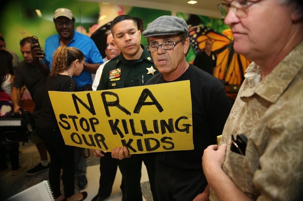 People protest against the National Rifle Association at the Broward County Court House during the first appearance in court via video link for high school shooter Nikolas Cruz Thursday in Fort Lauderdale, Florida. — AFP
