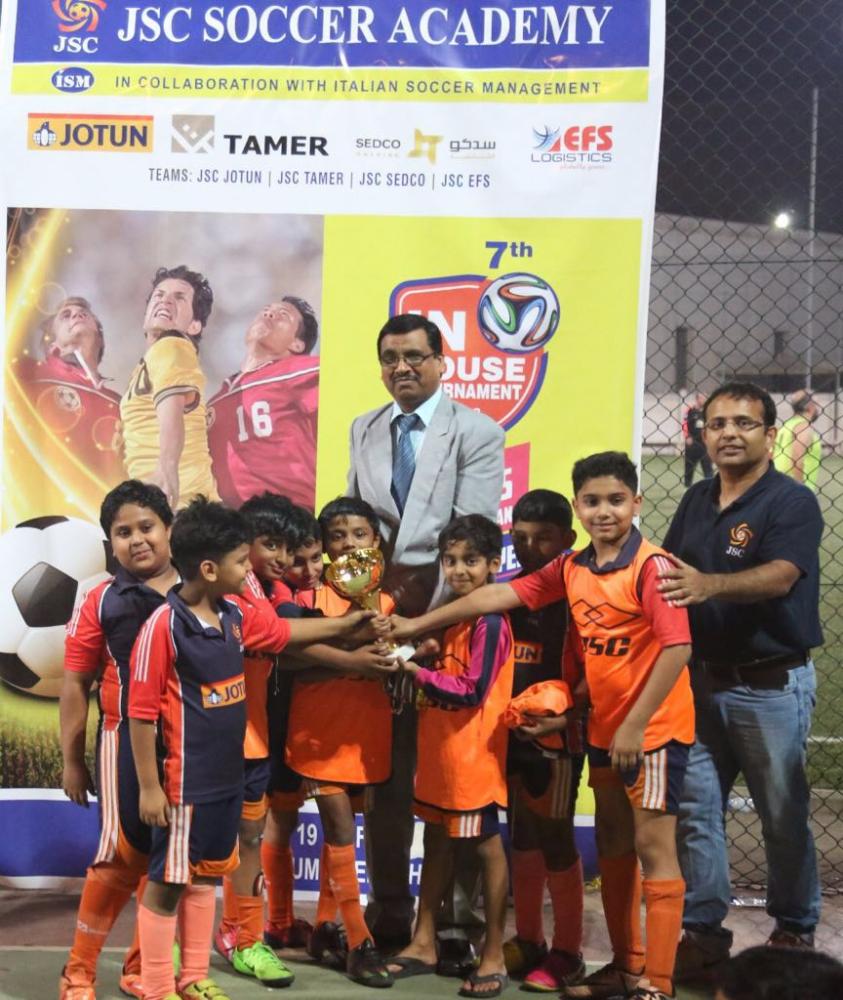 Chief coach Saleem P.R. and international coach Maxwell presenting the trophy to parents category winner Jotun. 