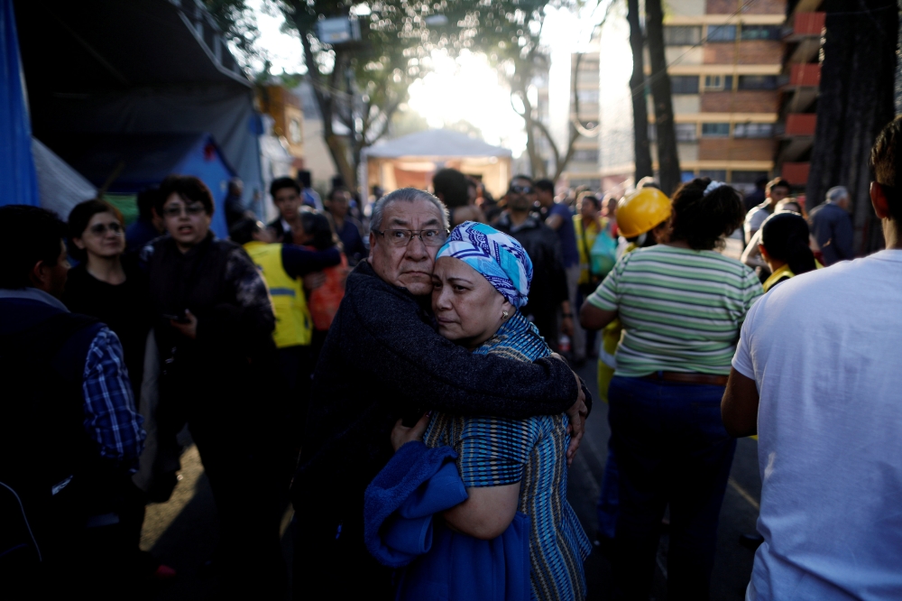 People react after an earthquake shook buildings in Mexico City, Mexico, on Friday. — Reuters