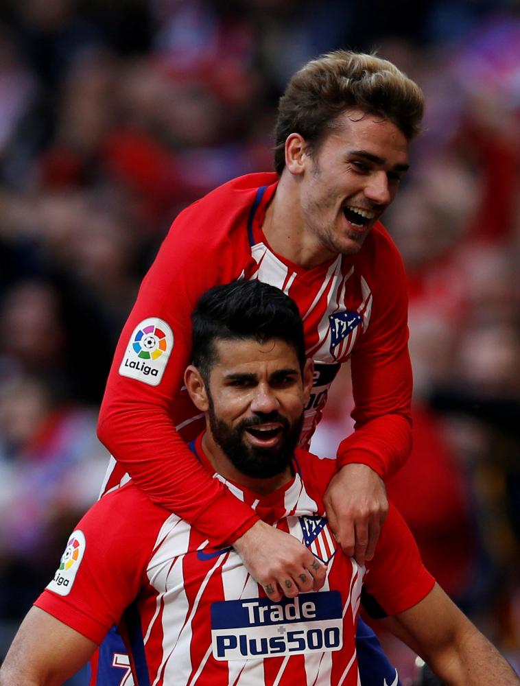 Atletico Madrid's Diego Costa celebrates scoring their second goal with Antoine Griezmann during their Spanish football league match against Athletic Bilbao at Wanda Metropolitano, Madrid, Sunday. — Reuters