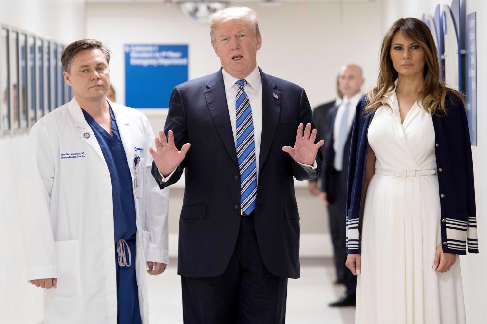 US President Donald Trump speaks with doctor Igor Nichiporenko, left, and First Lady Melania Trump while visiting first responders at Broward Health North hospital Pompano Beach, Florida, in this Feb.16, 2018 file photo. — AFP