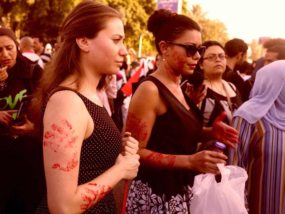 Women, with red paint on their bodies to symbolize blood, protest against sexual harassment in front of the opera house in Cairo in this file photo. — Reuters
