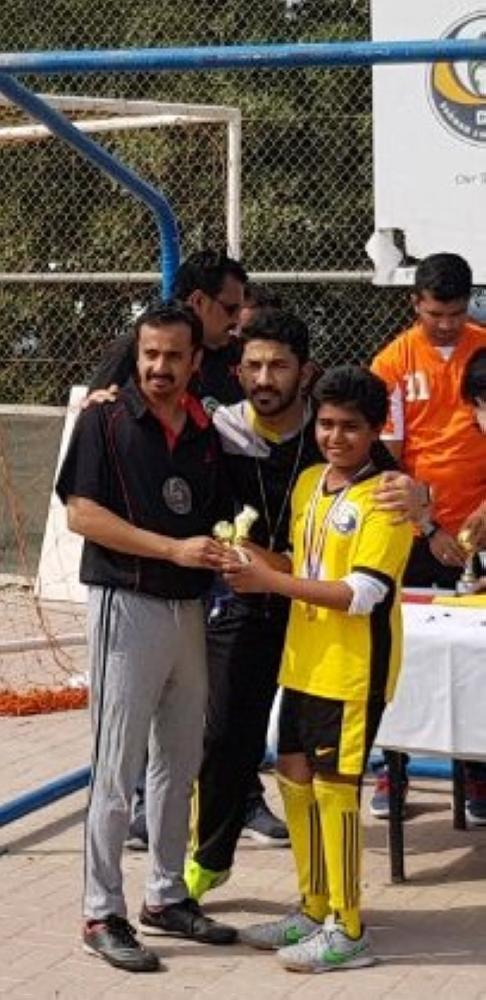 EC member Ramiz presenting the junior Top Scorer trophy to Ayaan.