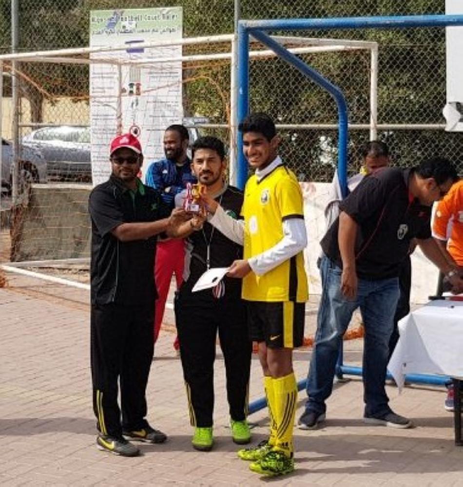EC member Ramiz presenting the junior Top Scorer trophy to Ayaan.