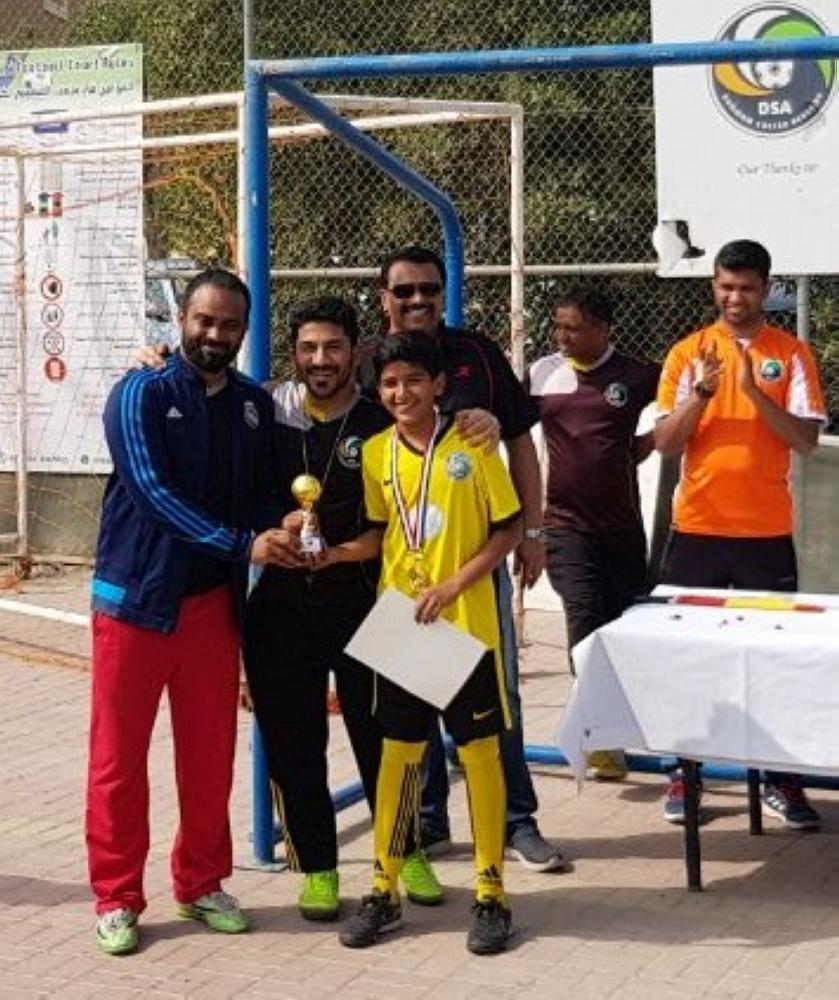 EC member Ramiz presenting the junior Top Scorer trophy to Ayaan.