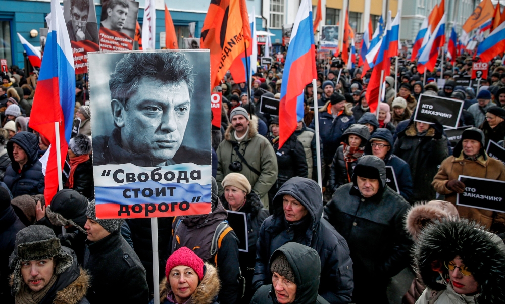 People carry flags andplacards during an opposition march in memory of murdered Kremlin critic Boris Nemtsov in central Moscow on Sunday. — AFP