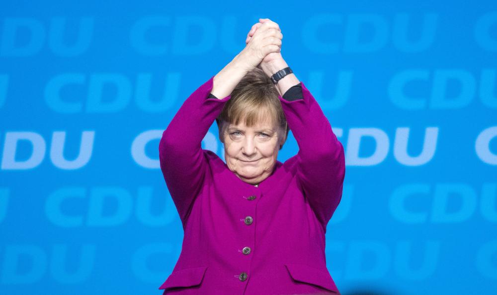 German Chancellor and leader of the Christian Democratic Union (CDU) Angela Merkel cheers after delivering her speech during the party’s congress in Berlin on Monday. — AFP