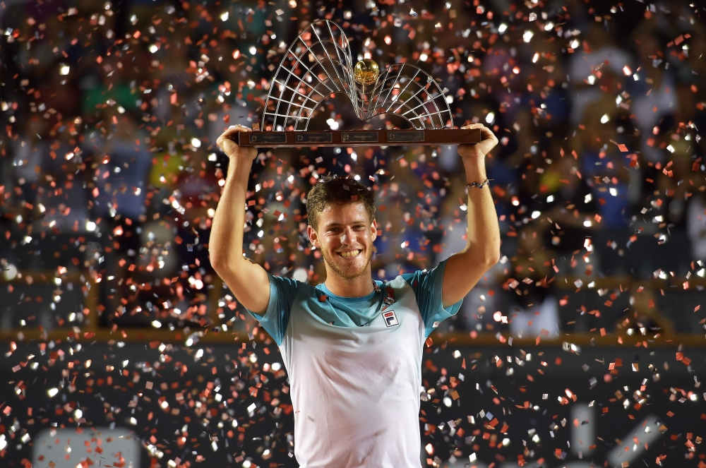 Argentina's Diego Schwartzman celebrates with the trophy after beating Spain's Fernando Verdasco during their ATP World Tour Rio Open singles final tennis match at the Jockey Club in Rio de Janeiro on Sunday. — AFP