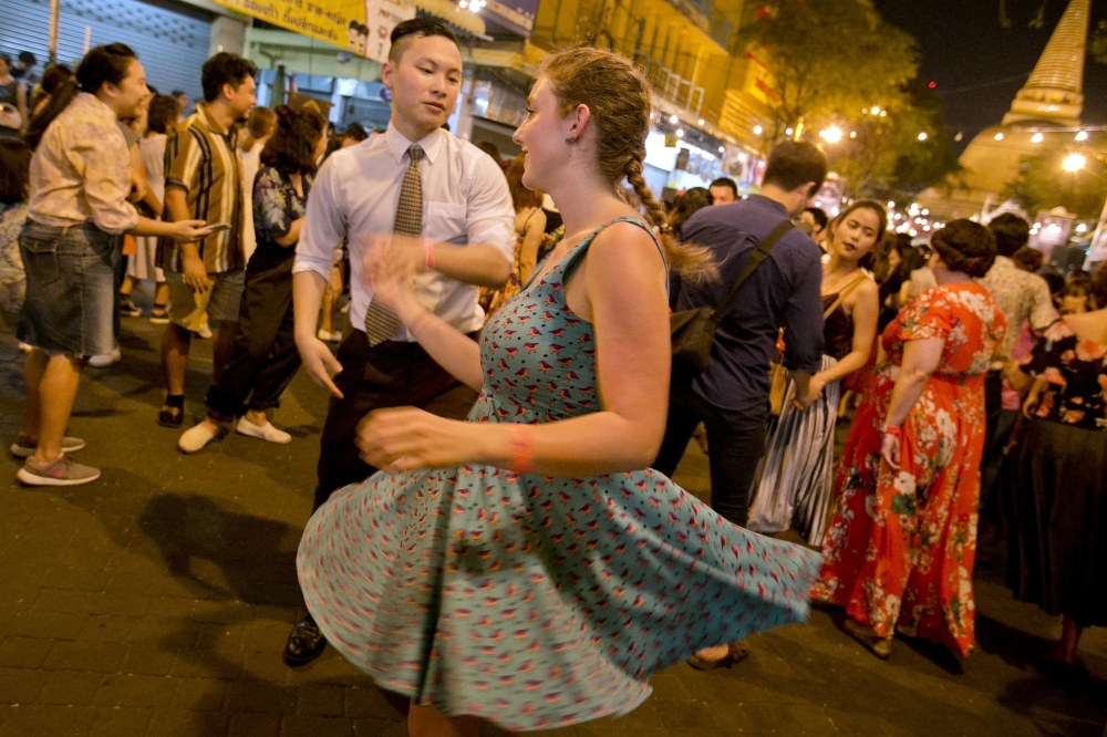People are seen swing dancing in front of Phra Pathom Chedi temple in the central Thai province of Nakhon Pathom on Monday. More than 300 enthusiasts, including foreign dancers, came out for the shindig on a street in Nakhon Pathom, about an hour outside of Bangkok. - AFP