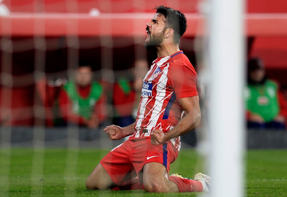 Atletico Madrid's Spanish forward Diego Costa celebrates after scoring a goal during the Spanish league football match against Sevilla FC at the Ramon Sanchez Pizjuan stadium in Sevilla on Sunday. — AFP