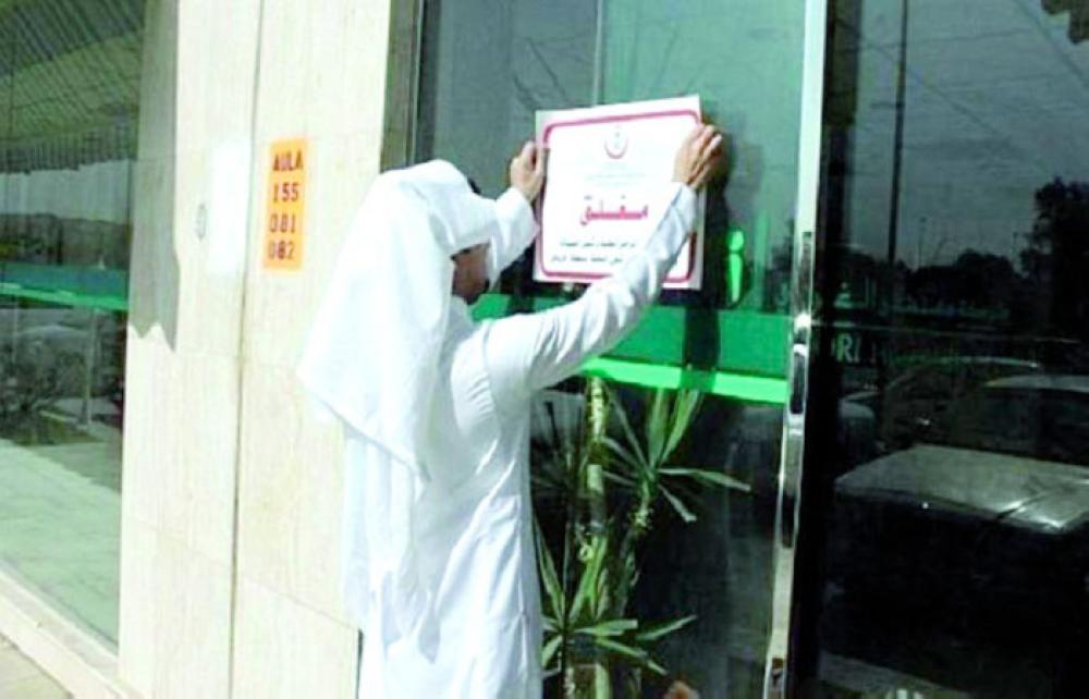 A municapility official puts closure notice on the hospital gate. — Okaz photo