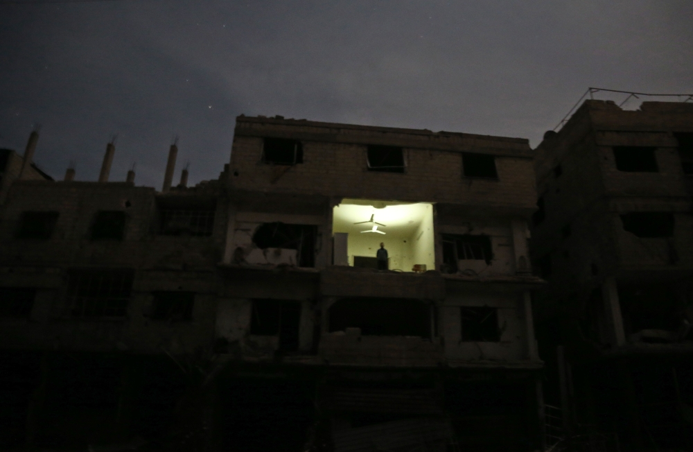 A man stands in a damaged building in Hamouria in the rebel-held enclave of Eastern Ghouta. — AFP