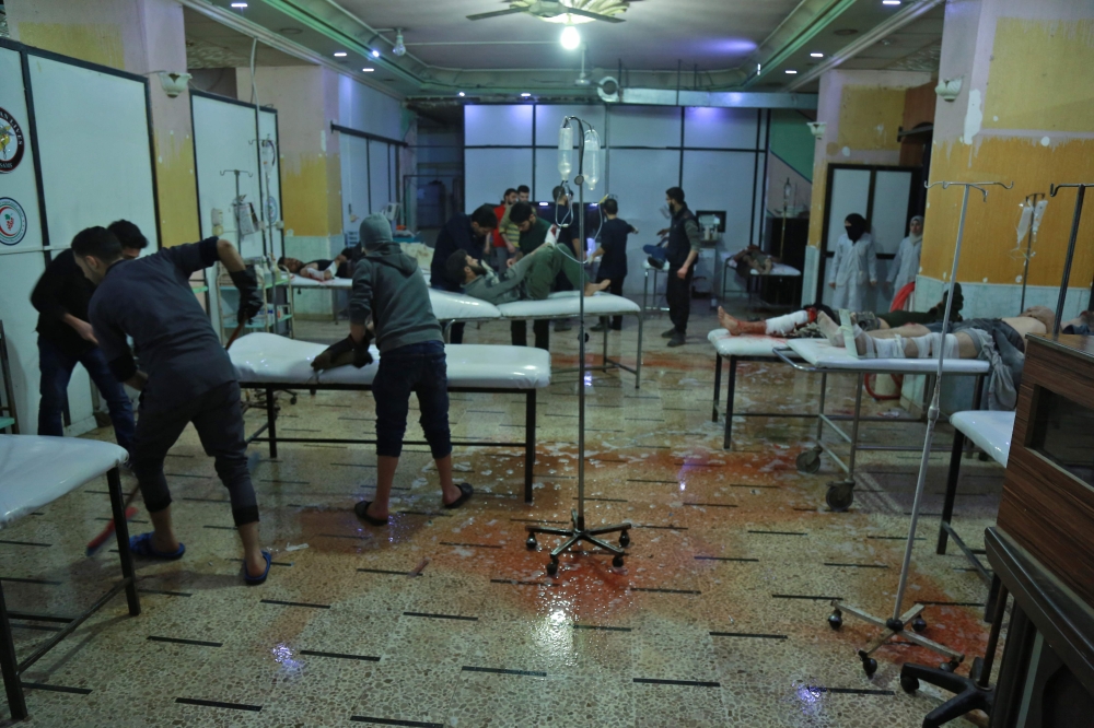 Wounded Syrian men are treated at a makeshift hospital in the rebel-held town of Douma, in the besieged Eastern Ghouta region on the outskirts of the capital Damascus, following air strikes by regime forces. — AFP