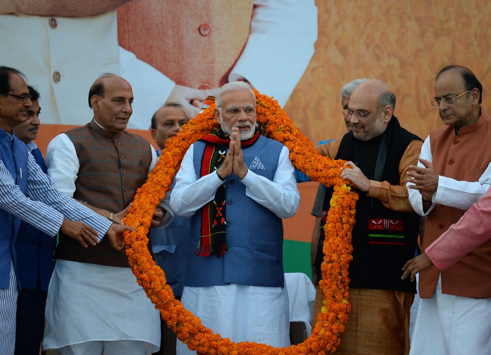 Indian Prime Minister Narendra Modi, center, gestures as he is garlanded by Bharatiya Janata Party leaders during the state election results of three northeast states at the BJP headquarters in the Indian capital New Delhi on Saturday. — AFP